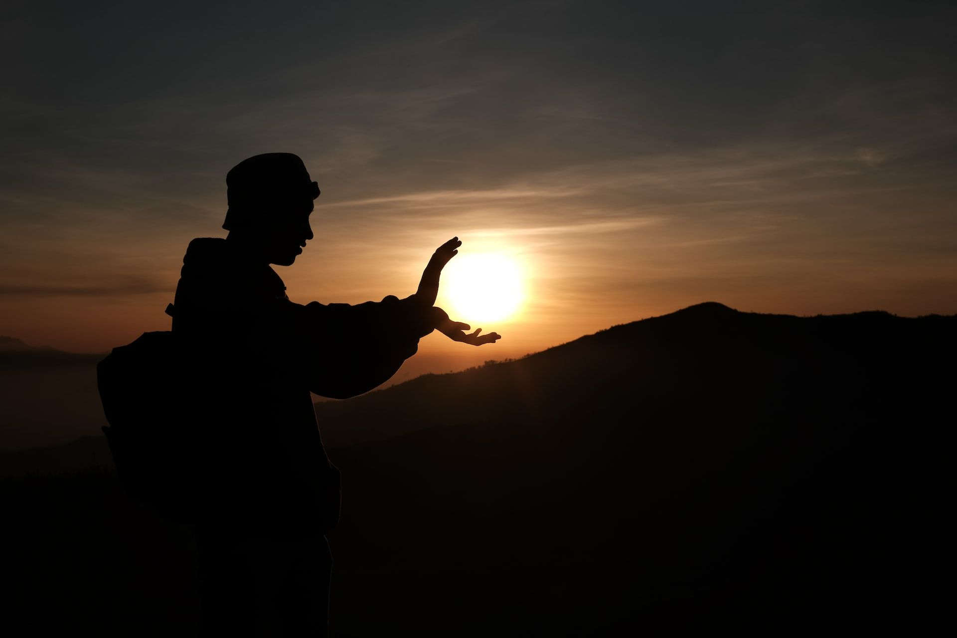 uomo diene il sole in mano al tramonto come metafora dell'autorealizzazione